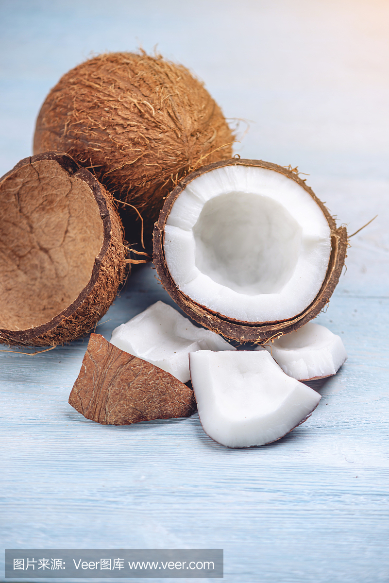 打開椰子與白色果肉在藍色木制背景。有機健康膳食產品廣泛應用于化妝品